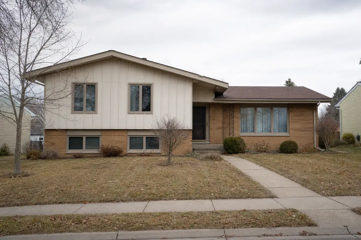 A 1970s tri-level split with mixed brick and vertical siding — we buy houses greenfield — Cudahy, WI