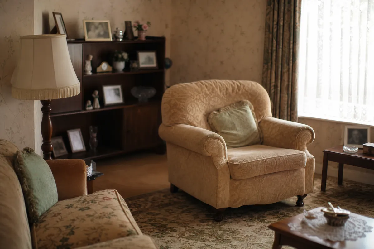 A quiet living room in an older home with dated furniture and framed pictures — sell inherited house — Cudahy, WI