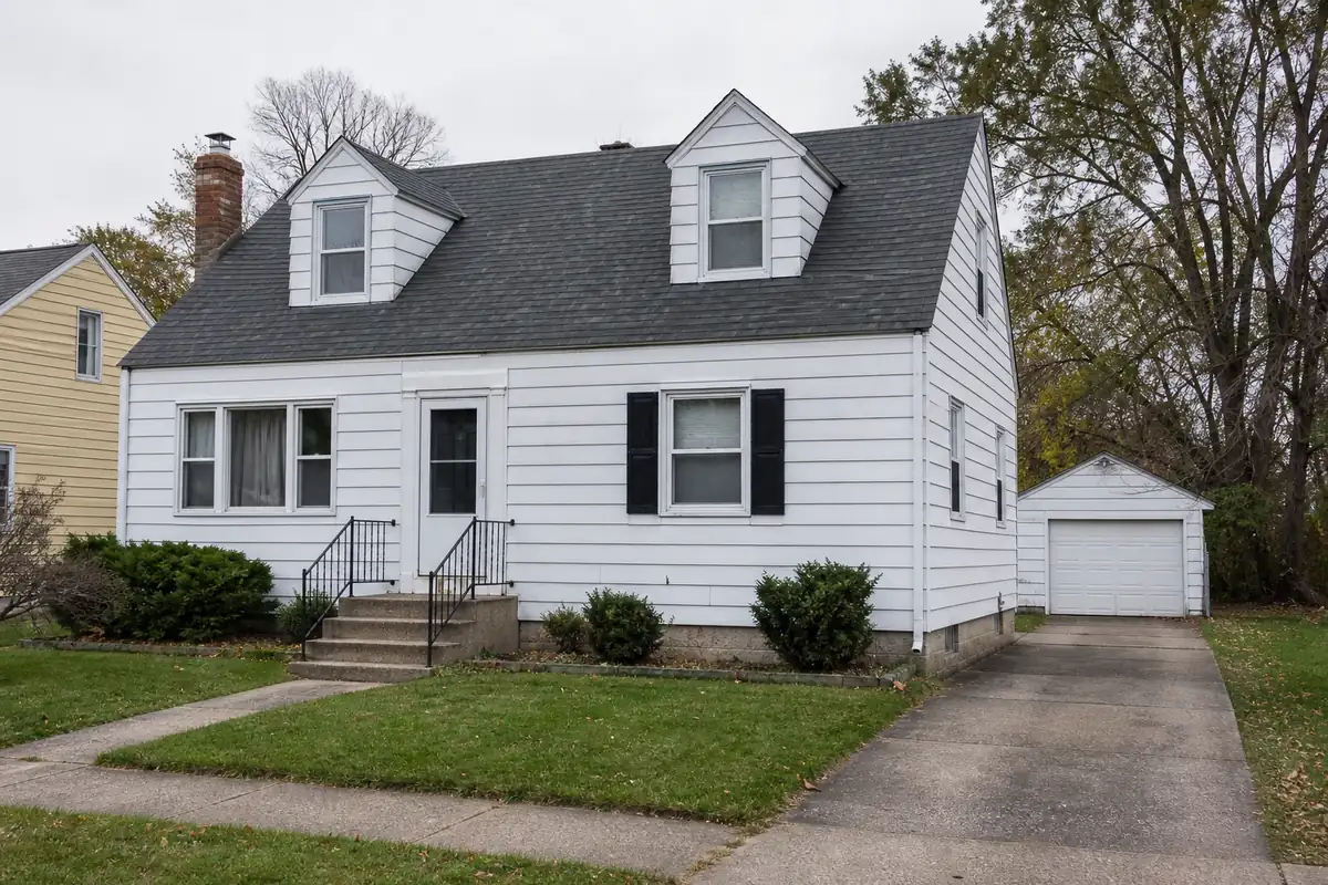 A compact post-war Cape Cod with dormer windows, aluminium siding and a — sell my house fast west allis — Cudahy, WI